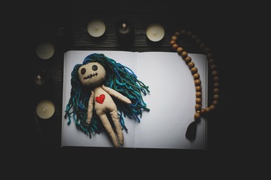 Image of Flat lay composition with voodoo doll on dark wooden table