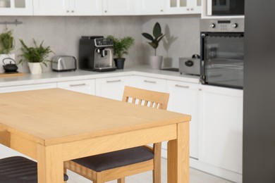 Stylish wooden table with chairs in kitchen. Interior design