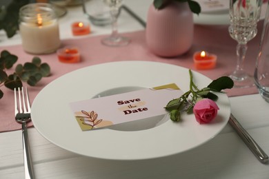 Photo of Romantic table setting with floral decor and candles, closeup