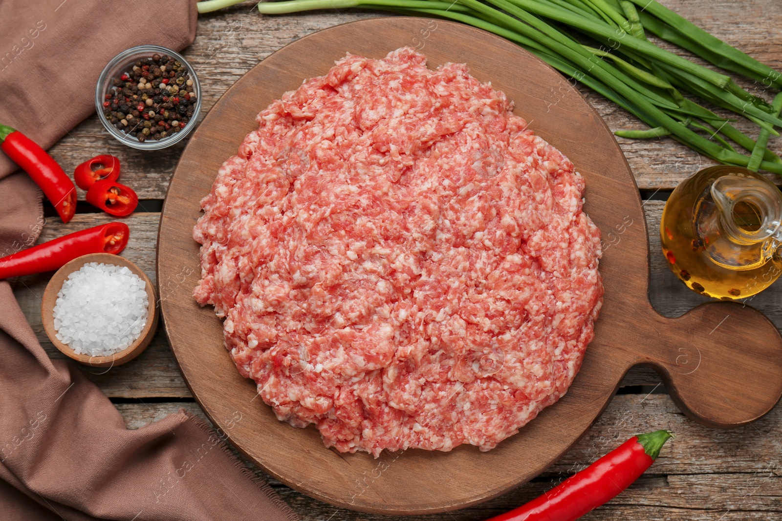 Photo of Board with raw fresh minced meat and ingredients on wooden table, flat lay