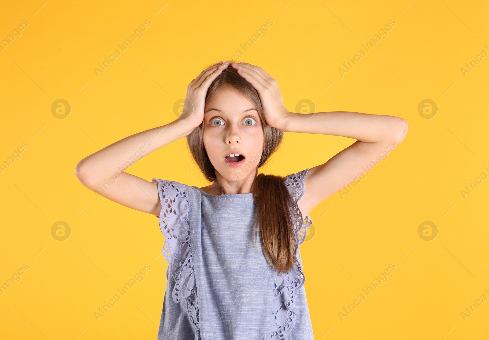 Photo of Portrait of emotional little girl on yellow background