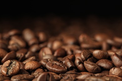 Photo of Heap of aromatic roasted coffee beans, closeup