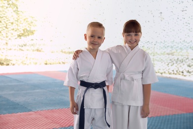 Photo of Children in kimono during karate practice on tatami outdoors