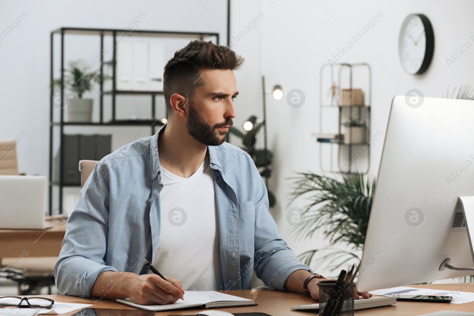 Photo of Man working on computer at table in office