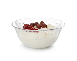 Photo of Creamy rice pudding with red currant and hazelnuts in bowl on white background
