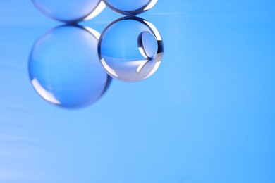 Photo of Transparent glass balls on blue background. Space for text
