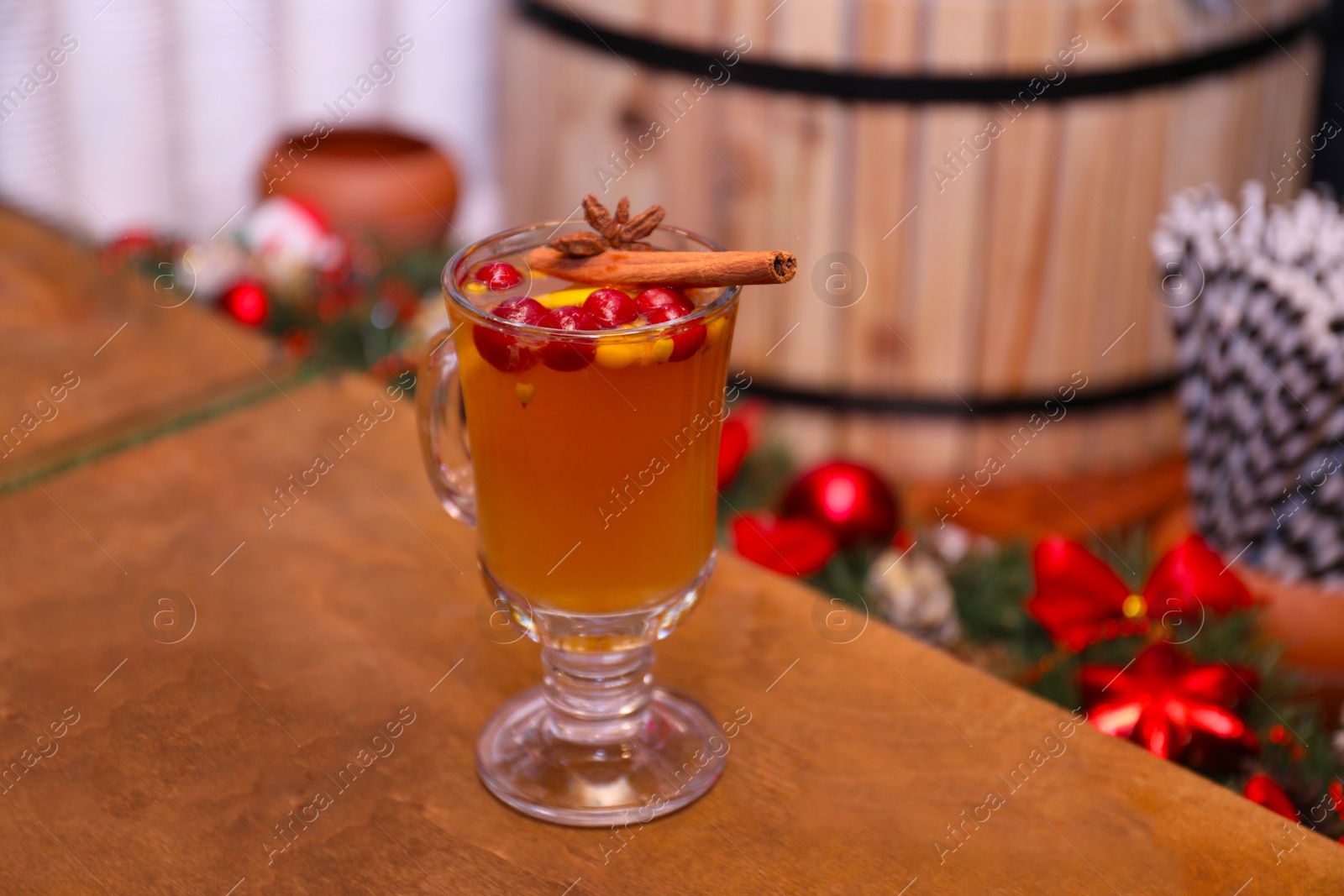 Photo of Tasty aromatic mulled wine on wooden table