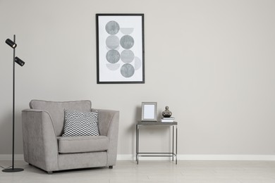 Photo of Stylish armchair near grey wall, space for text. Interior design