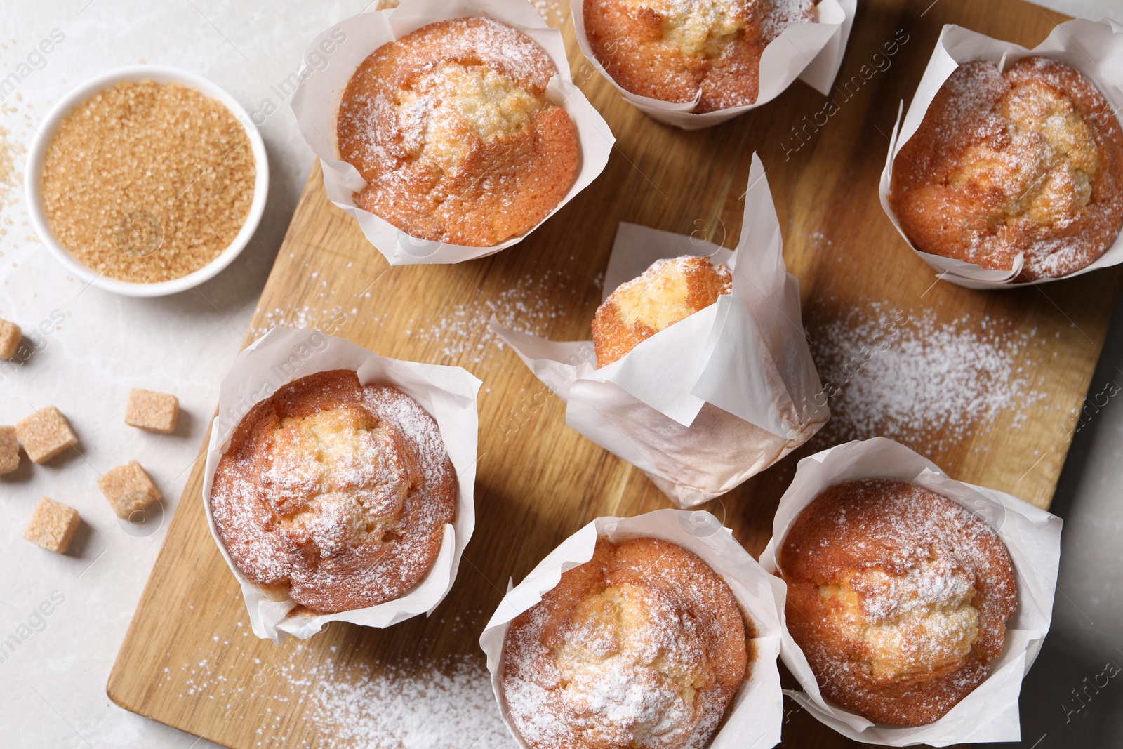 Photo of Delicious muffins on light table, flat lay