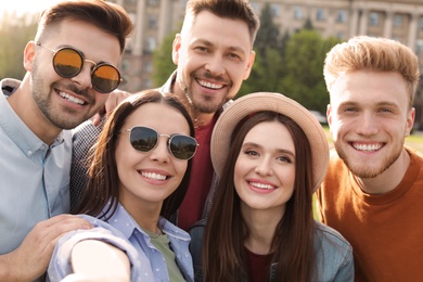 Photo of Happy people taking selfie outdoors on sunny day