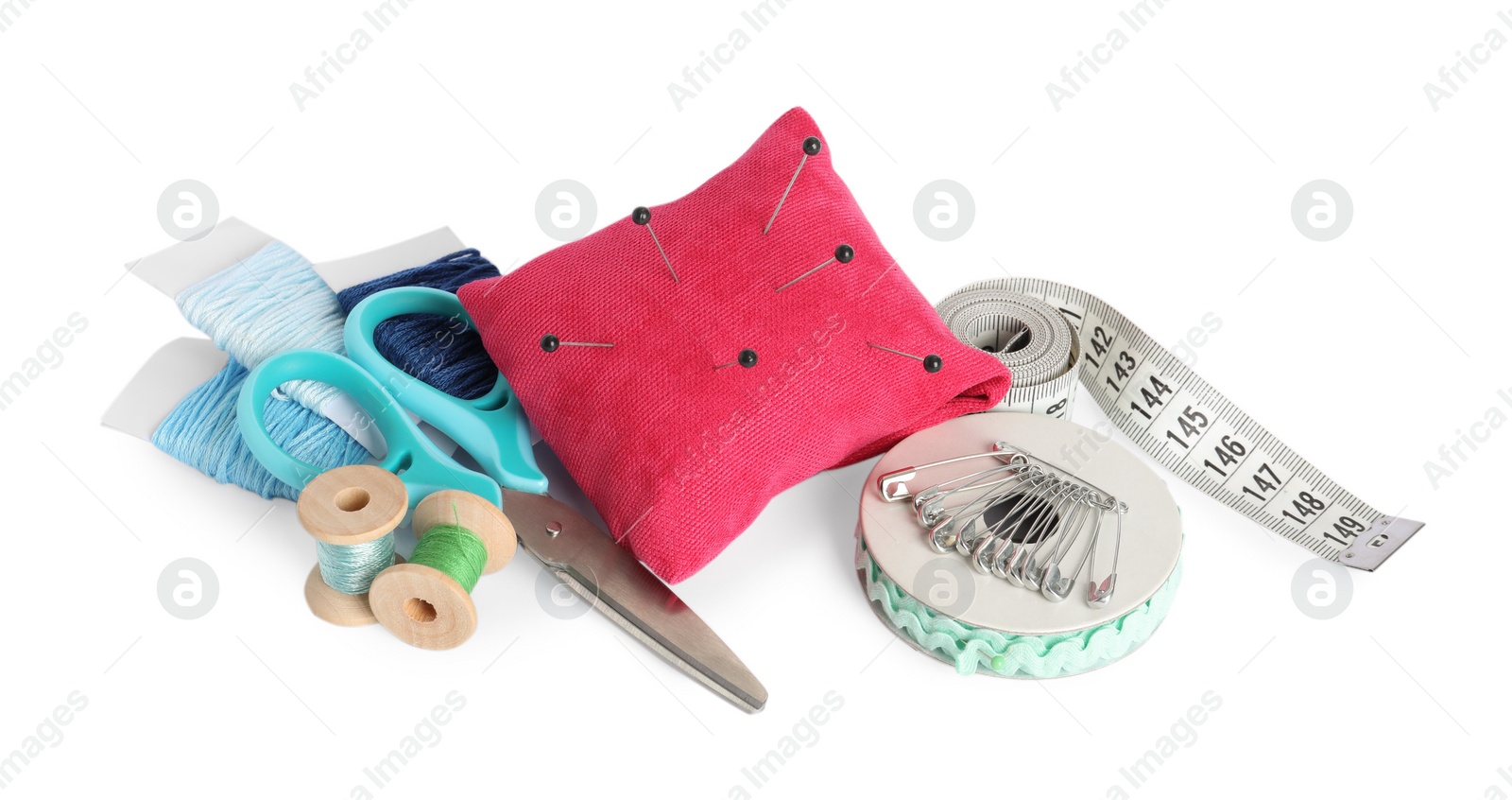 Photo of Pincushion, pins and other sewing tools isolated on white