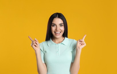 Photo of Woman showing number two with her hands on yellow background