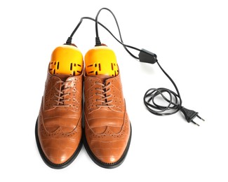 Photo of Pair of stylish shoes with modern electric footwear dryer on white background
