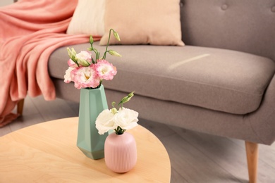 Photo of Beautiful flowers in vases and space for text on blurred background. Element of interior design