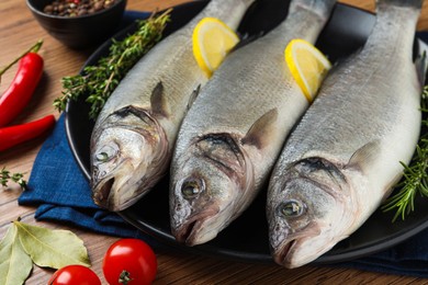 Photo of Tasty sea bass fish with spices on wooden table, closeup