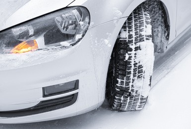 Photo of Car with winter tires on snowy road, closeup