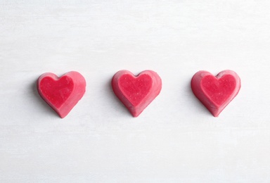 Heart shaped berry ice cubes on light background, flat lay