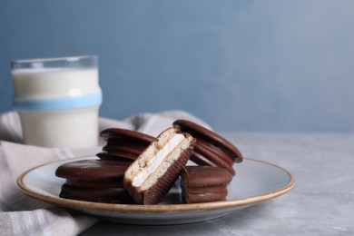 Tasty choco pies and milk on grey table