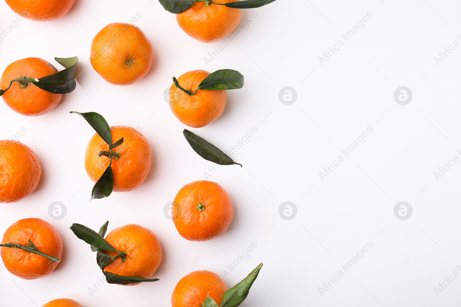 Photo of Fresh ripe tangerines with leaves on white background, flat lay. Space for text