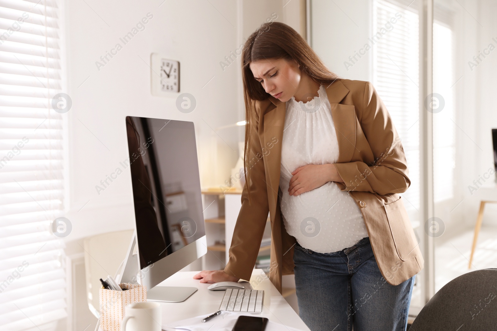 Photo of Tired pregnant woman working at home. Maternity leave