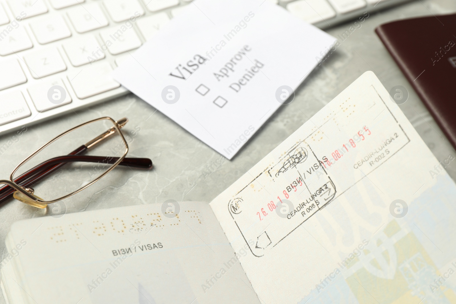 Photo of Moldova, Ceadir-Lunga - June 13, 2022: Passports with visa stamps on grey marble table, closeup