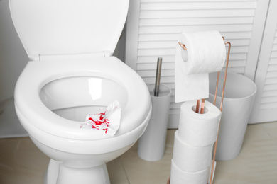 Photo of Sheet of paper with blood on toilet seat in bathroom