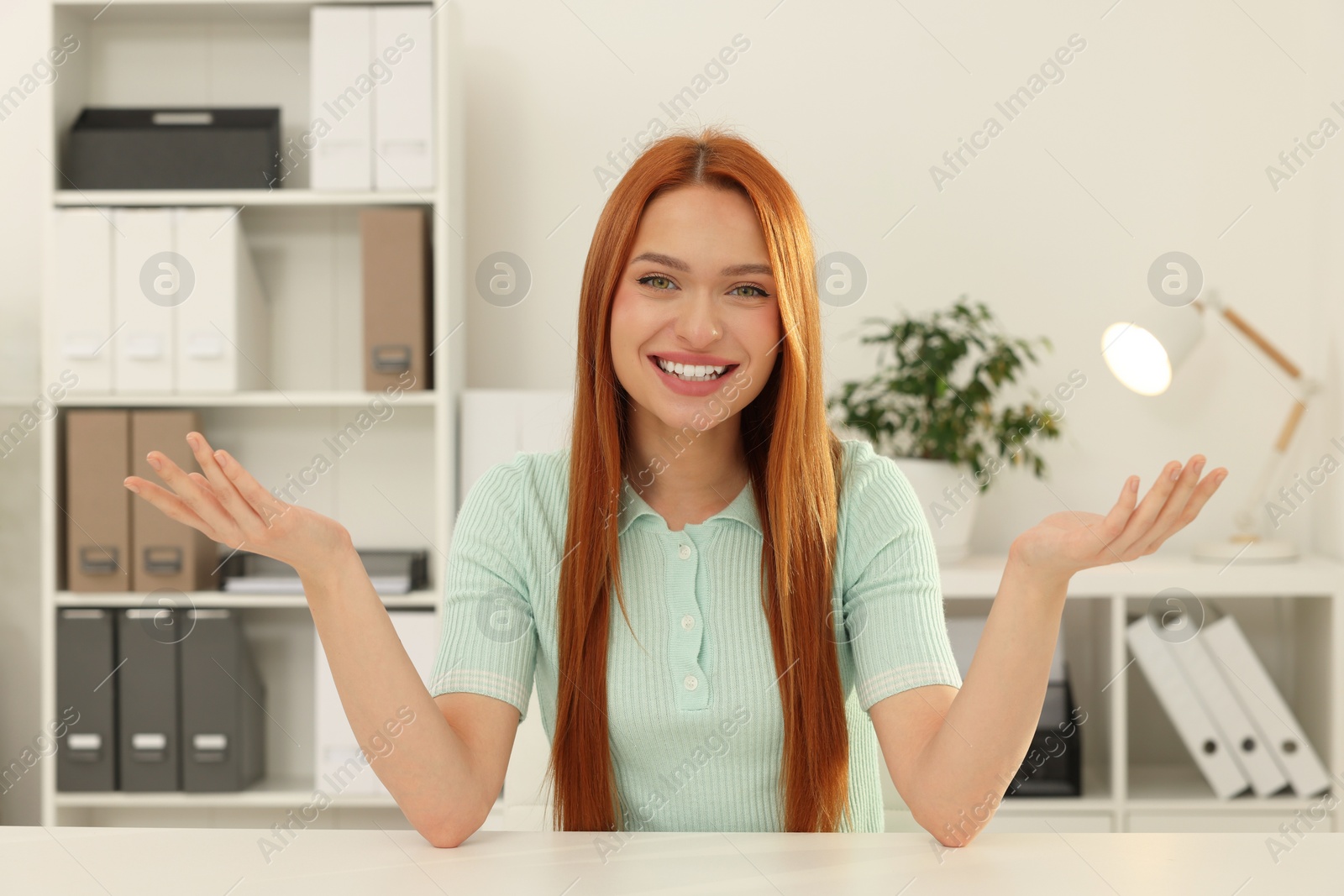 Photo of Young woman having video chat at table in office, view from web camera