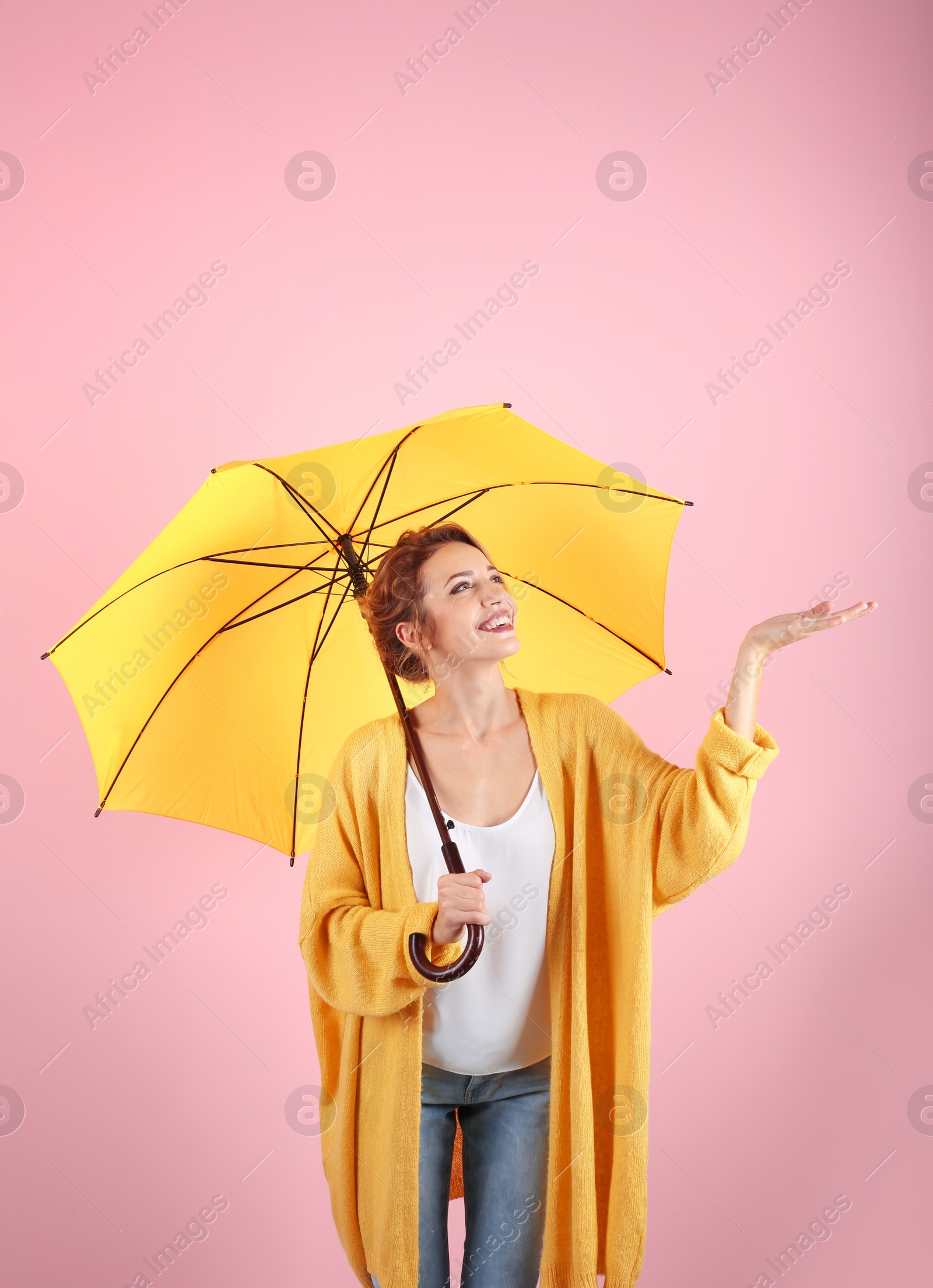 Photo of Woman with yellow umbrella on color background