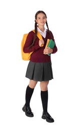 Teenage girl in school uniform with books and backpack on white background