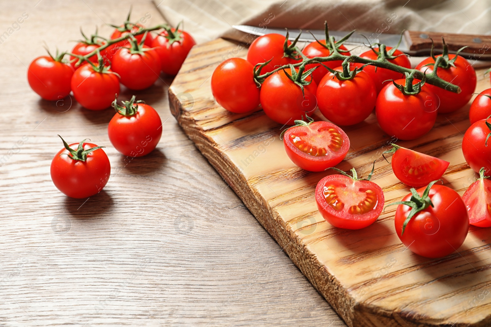 Photo of Board with cherry tomatoes on wooden background