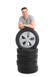 Young man with car tires on white background
