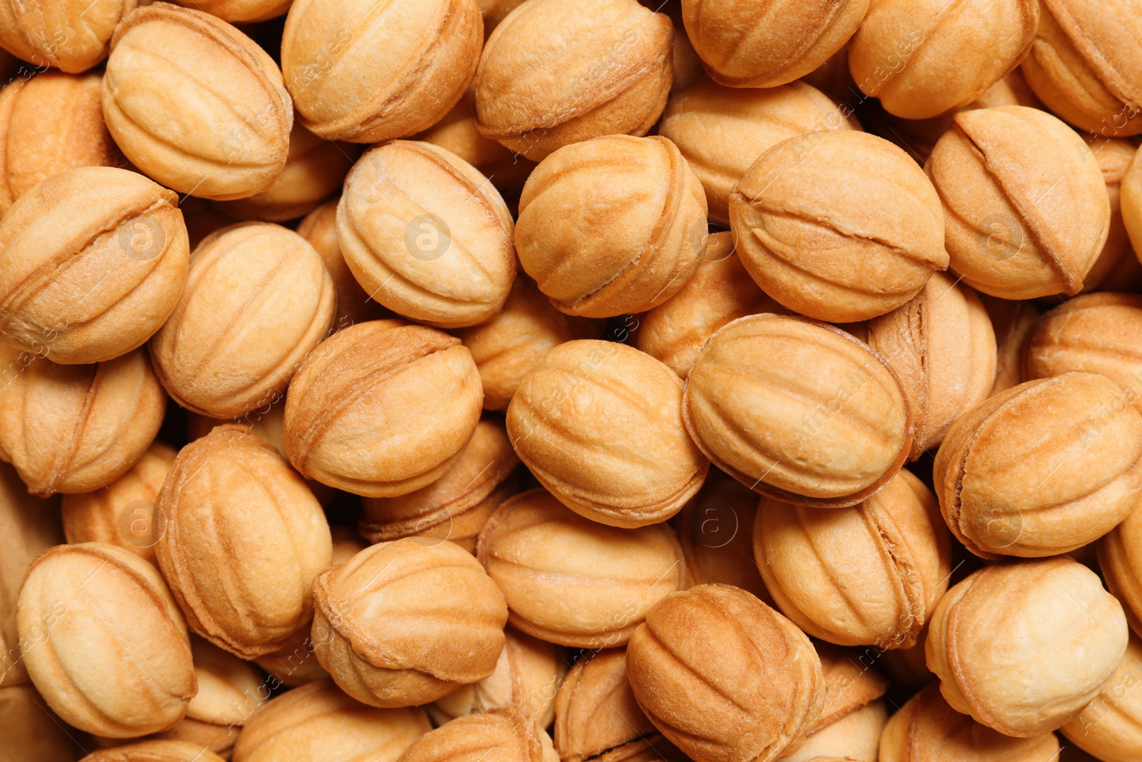 Photo of Delicious nut shaped cookies with boiled condensed milk as background, top view