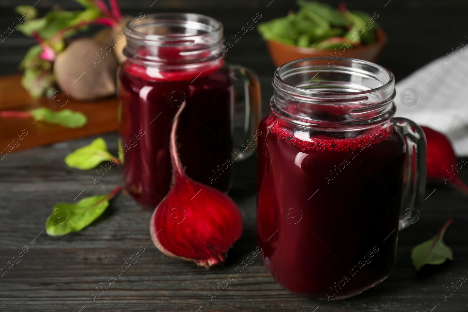 Photo of Fresh beet juice and raw vegetable on dark wooden table
