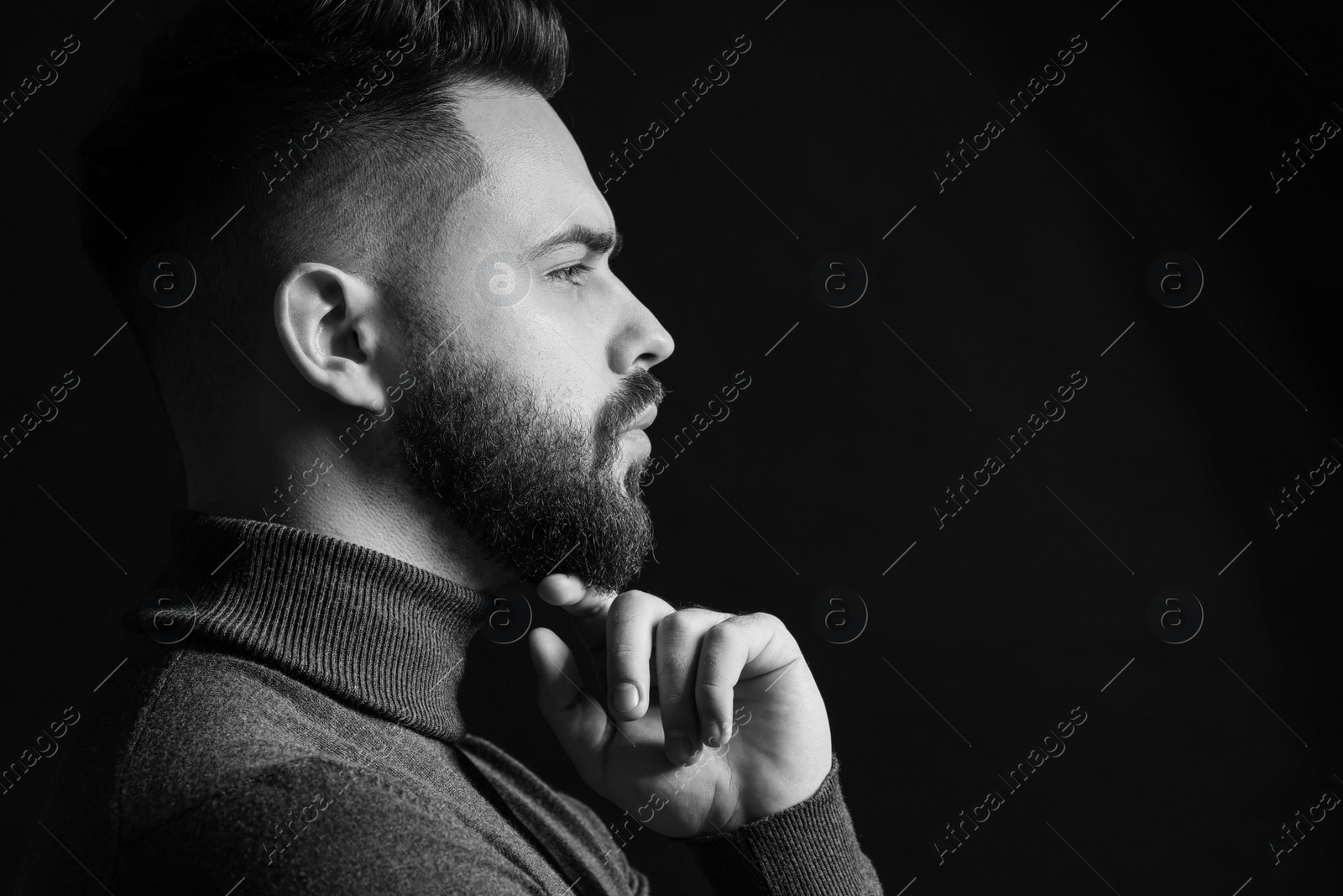 Photo of Portrait of handsome bearded man on dark background. Black and white effect