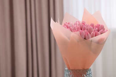 Photo of Bouquet of beautiful pink tulips in vase indoors, space for text
