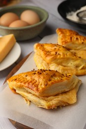 Photo of Fresh delicious puff pastry on parchment, closeup