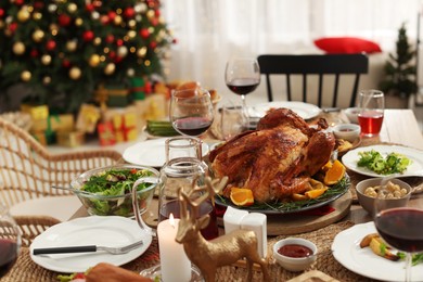 Photo of Festive dinner with delicious baked turkey and wine on table indoors. Christmas celebration