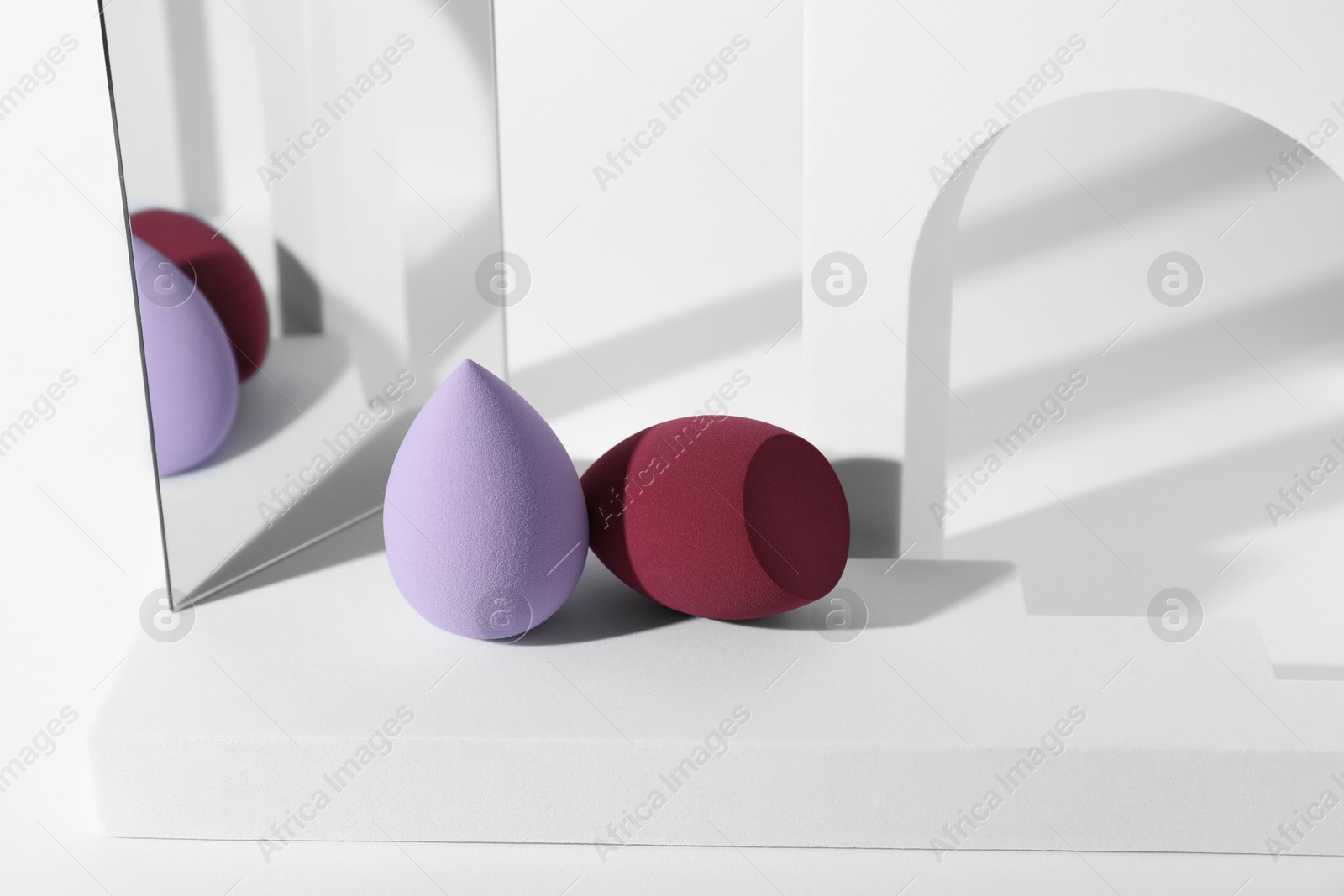 Photo of Stylish presentation of makeup sponges on white background