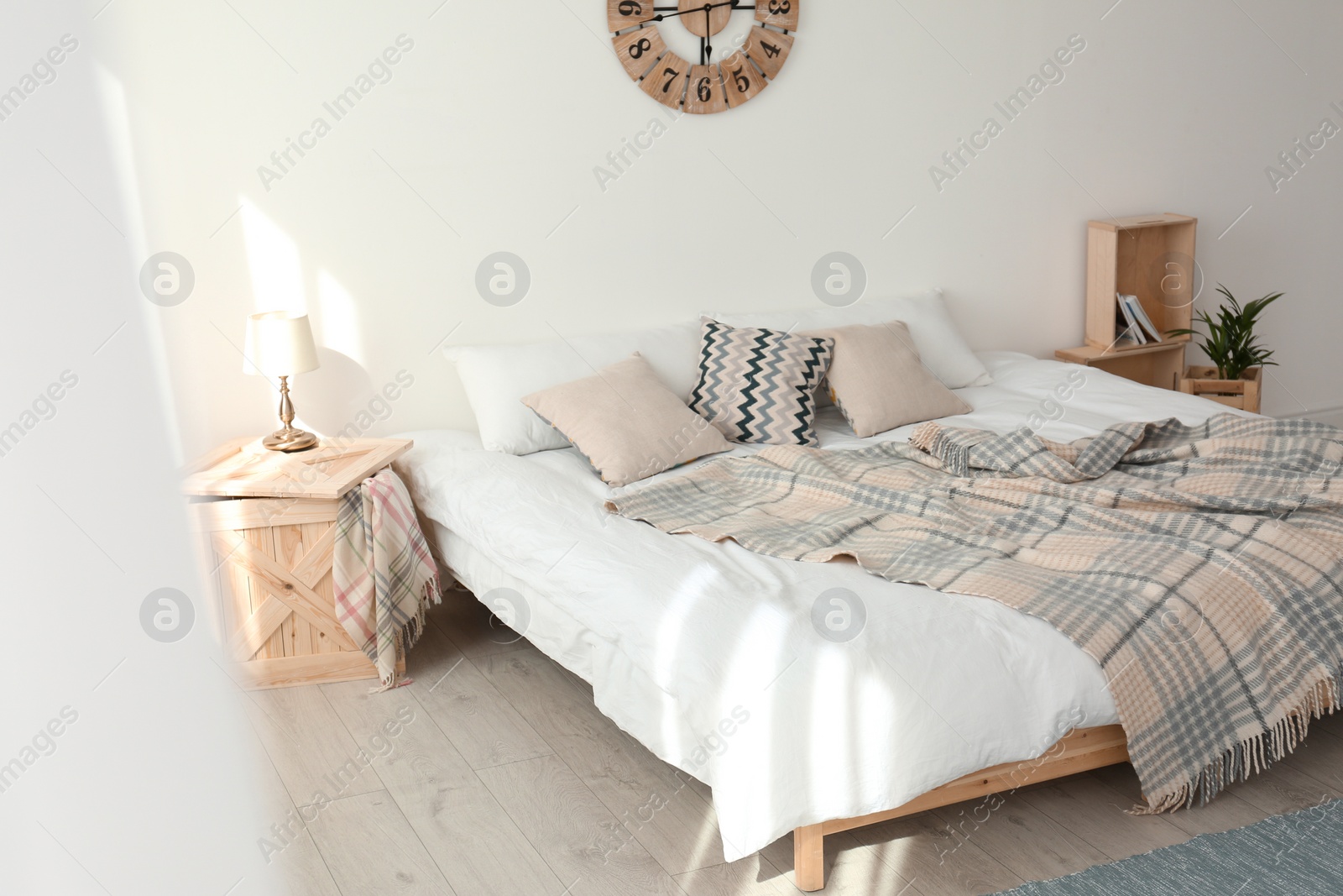 Photo of Bed with pillows and plaid in modern room interior