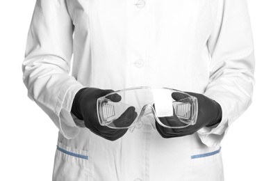 Photo of Doctor in medical gloves holding safety glasses on white background