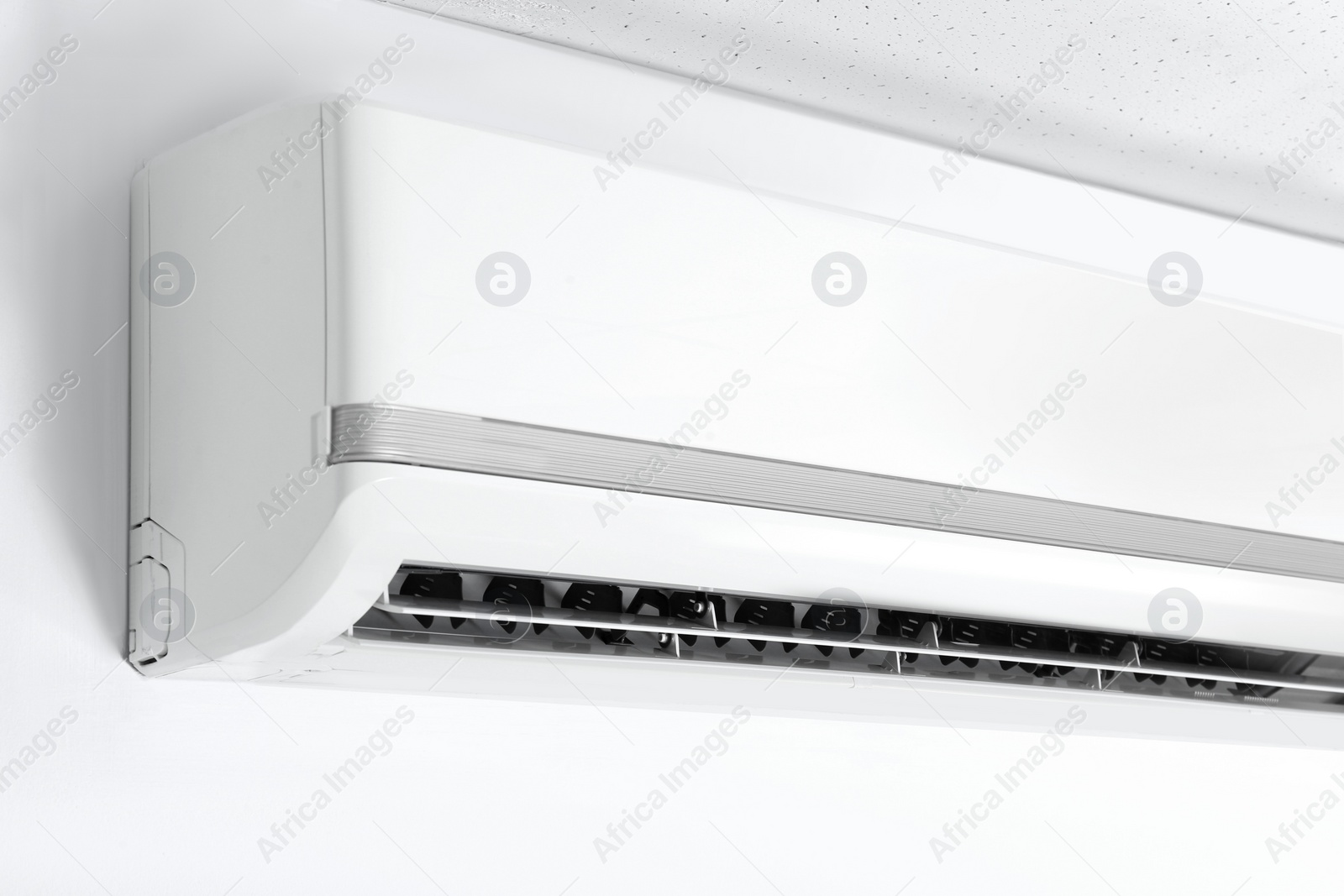 Photo of Modern air conditioner on white wall indoors, closeup