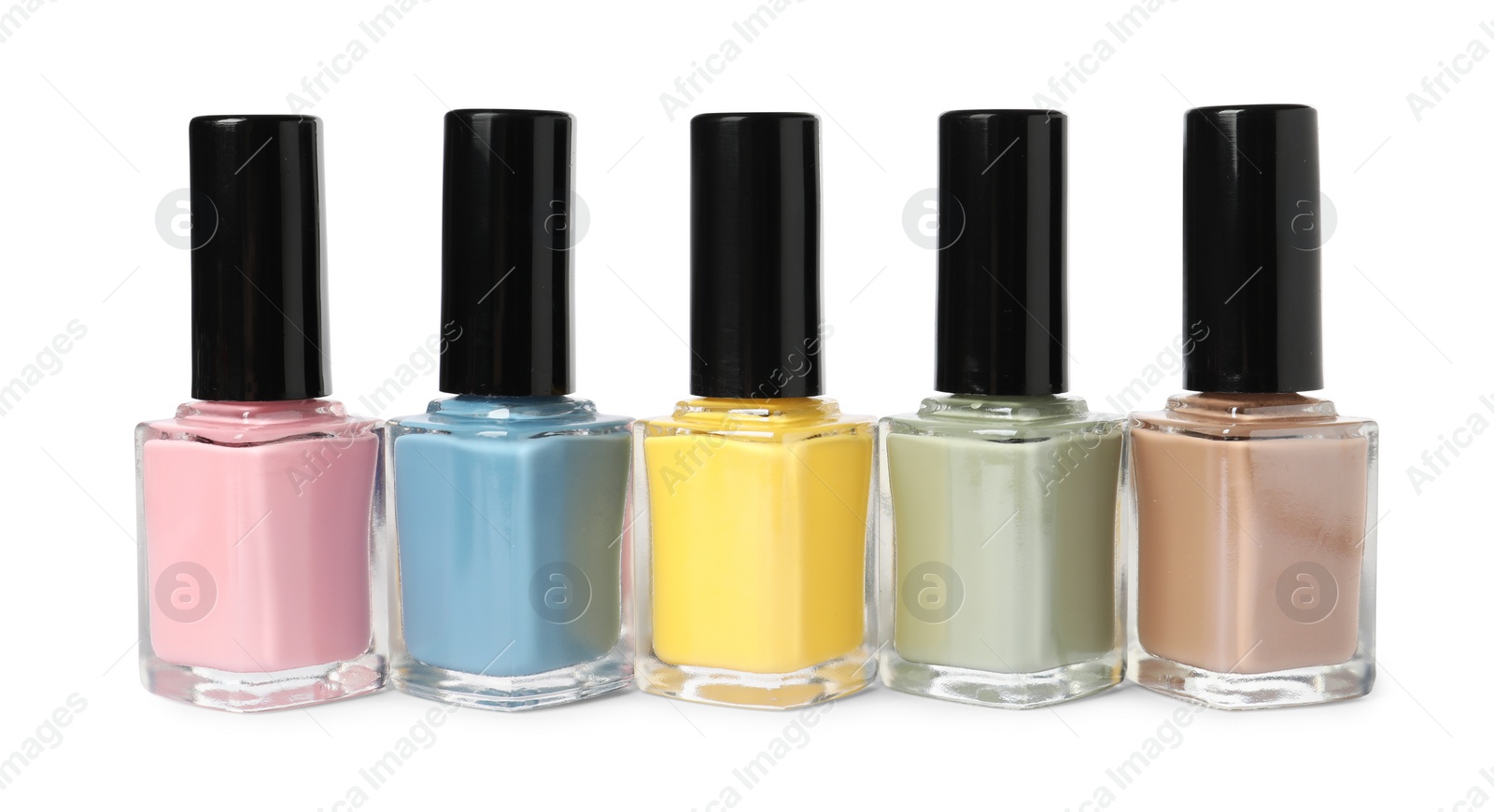 Photo of Pastel nail polishes in bottles isolated on white