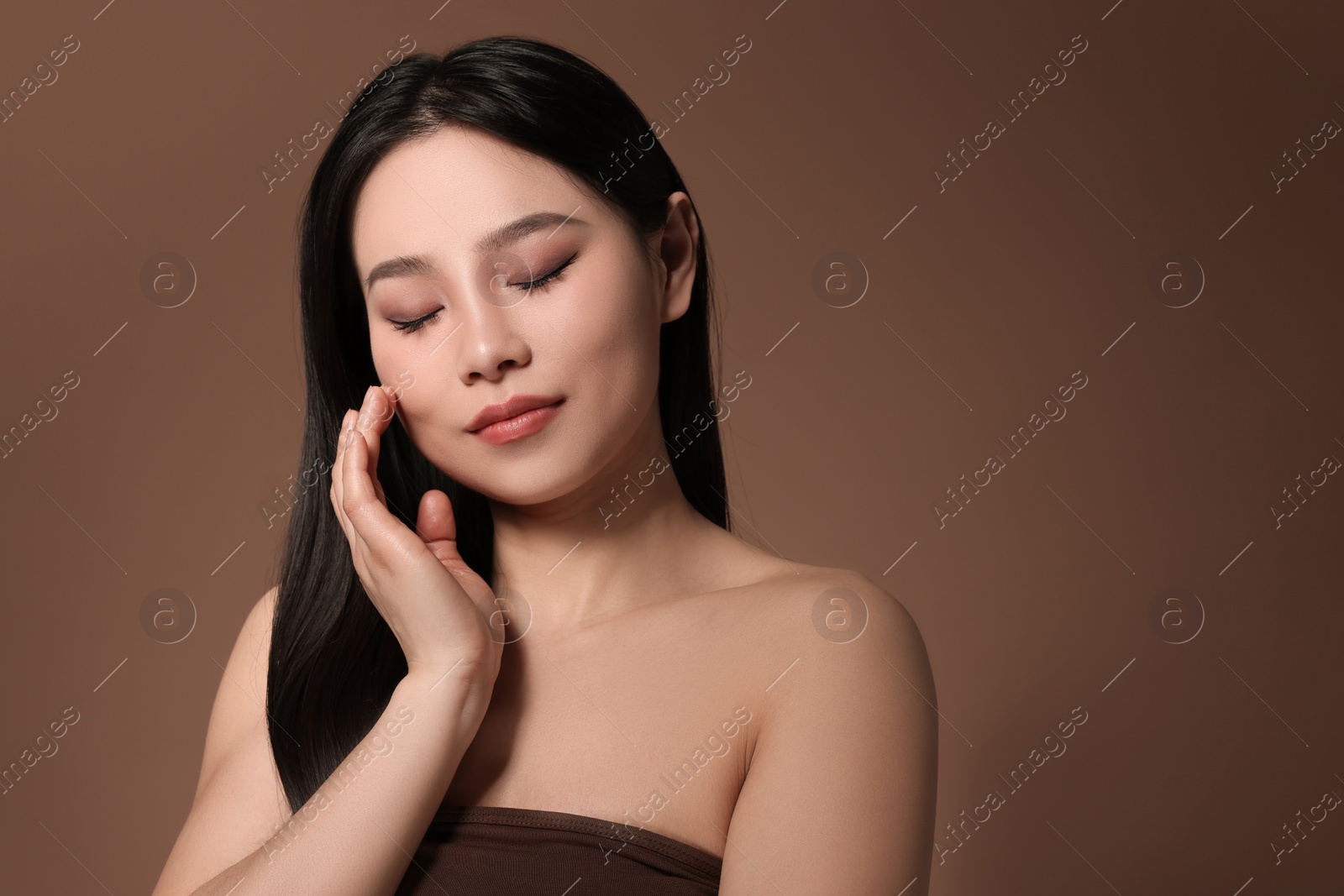 Photo of Portrait of beautiful woman on brown background