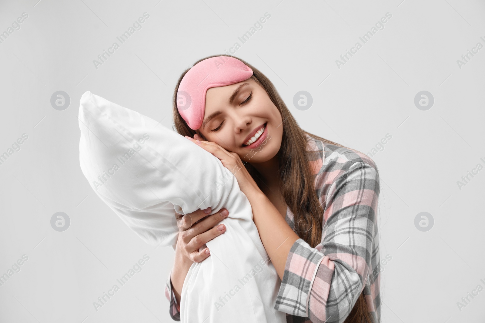 Photo of Beautiful woman with pillow on light grey background. Bedtime