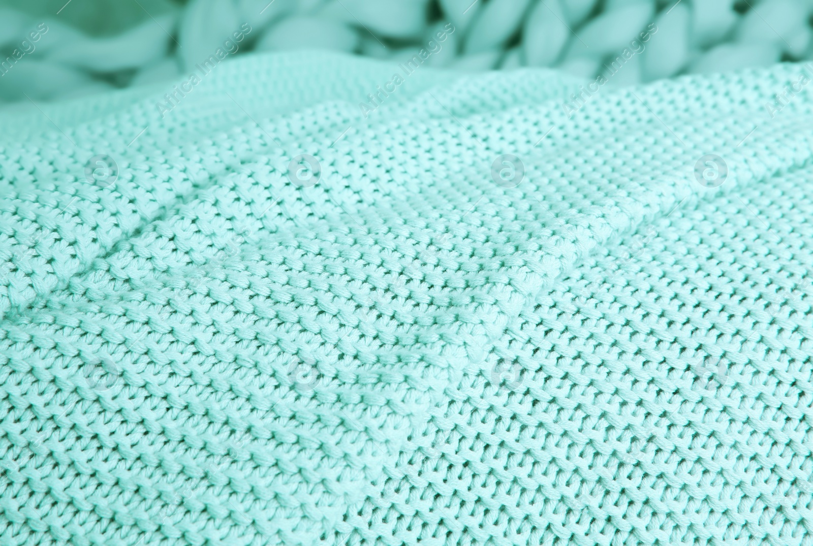 Photo of Texture of warm knitted mint blanket, closeup