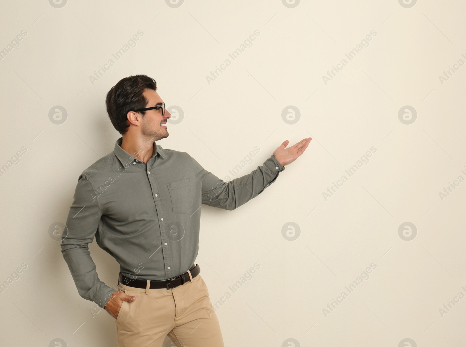 Photo of Young male teacher with glasses on beige background. Space for text