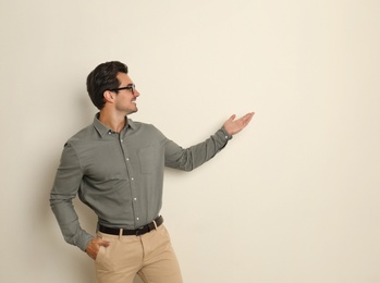 Photo of Young male teacher with glasses on beige background. Space for text
