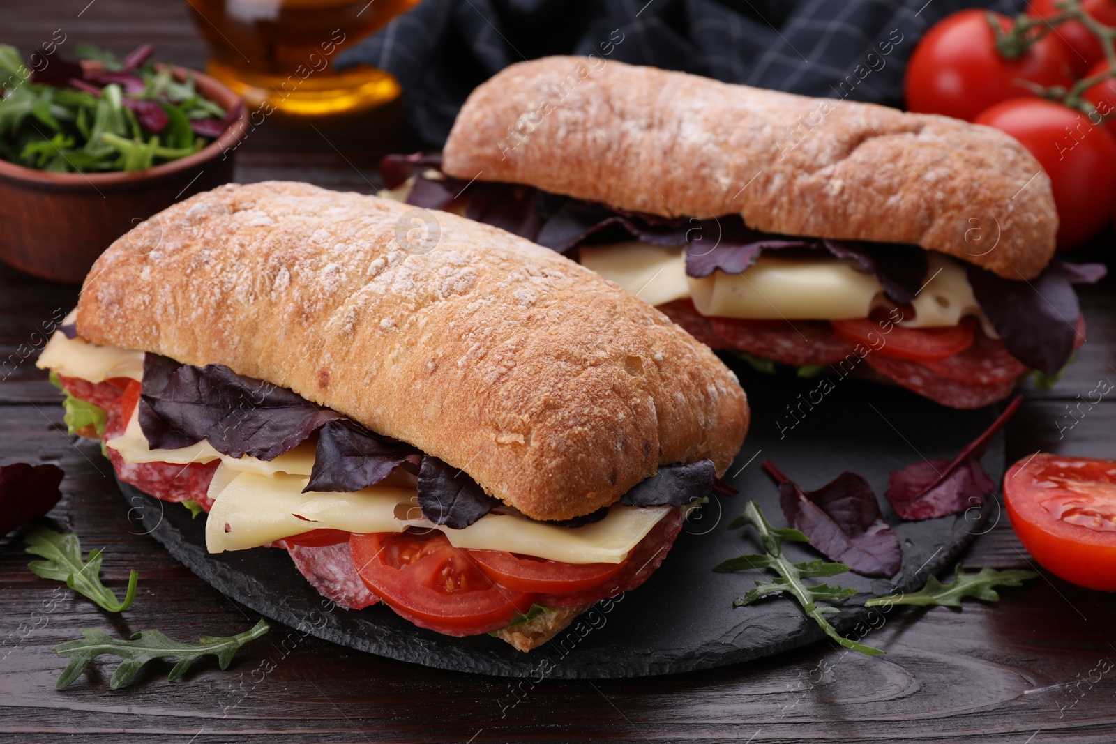 Photo of Delicious sandwiches with cheese, salami, tomato on wooden table, closeup