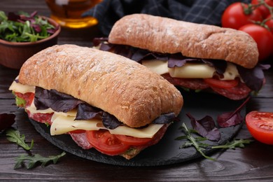 Delicious sandwiches with cheese, salami, tomato on wooden table, closeup