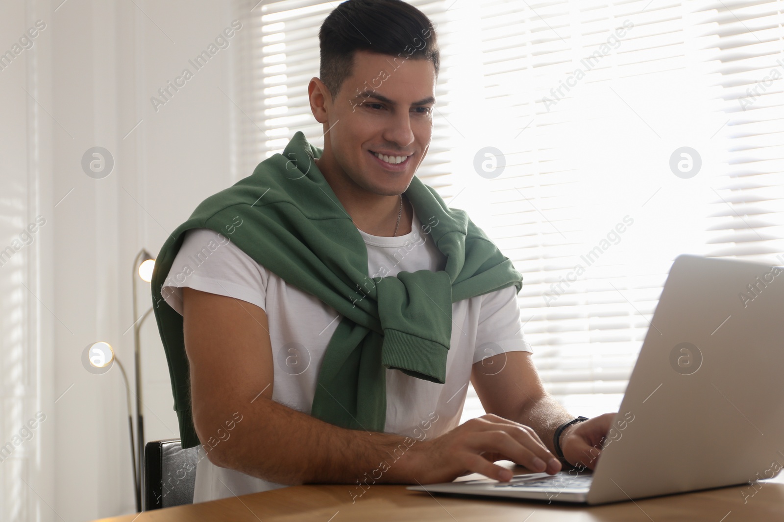 Photo of Freelancer working on laptop at table indoors